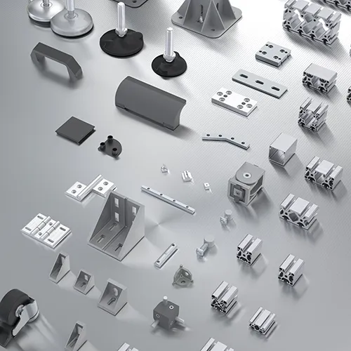 A spread of profiles and accessories compatible with the IM slot. Visible are aluminum profiles of various sizes and shapes, along with accessories such as anchoring bases, swivel feet, handles, and joints.